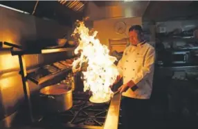  ??  ?? Chef Mohammed- Faizul Haque uses lemon juice to make flames as he demonstrat­es how to give a smoky flavor to dishes such as Kuchi chili chicken at the Taste of India curry restaurant in London. Matt Dunham, The Associated Press