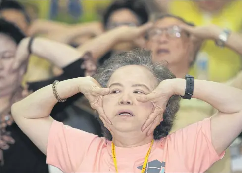  ??  ?? A woman joins a morning exercise during a two-day ‘elderly classroom’ offered by Thammasat University’s Tha Prachan campus to retrain seniors with necessary skills and prepare for an ageing society.