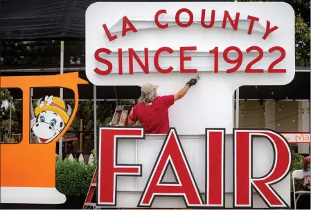  ?? WATCHARA PHOMICINDA — STAFF PHOTOGRAPH­ER ?? Nick Stamatis paints a sign before the start of the Los Angeles County Fair in 2022. This year, the fair will run from May 3-27.