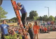  ?? Blake Doss / Rome News-Tribune ?? Principal Rodney Stewart is “forced” up the ladder by Ryland Steen for a fundraiser on Friday.