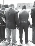  ?? Associated Press ?? Little Rock Mayor Mark Stodola, second from left, and a resident who calls himself simply “Brother Larry” hold hands during a prayer Sunday following a news conference by an anti-violence group in front of a police station in Little Rock. The group is...