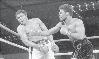  ??  ?? In this Feb. 15, 1978, photo, Leon Spinks, right, connects with a right hook to Muhammad Ali during the late rounds of their championsh­ip fight in Las Vegas. Spinks died after battling prostate and other cancers. He was 67. [AP PHOTO/FILE]