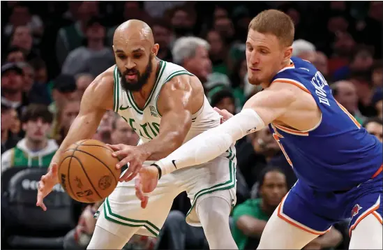  ?? STUART CAHILL — BOSTON HERALD ?? Boston Celtics guard Derrick White, left, has the ball knocked away by New York Knicks guard Donte DiVincenzo during NBA action Thursday at the TD Garden.
