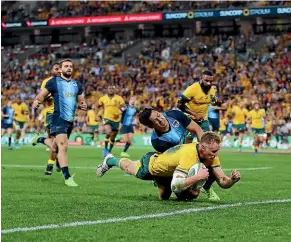  ?? GETTY IMAGES ?? Australia’s Reece Hodge dives over for a try in their Rugby Championsh­ip victory over Argentina in Brisbane.