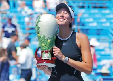  ?? AARON DOSTER / USA TODAY SPORTS ?? Spain’s Garbine Muguruza embraces the Rookwood Cup after defeating Simona Halep of Romania in Sunday’s final of the Western and Southern Open in Mason, Ohio.