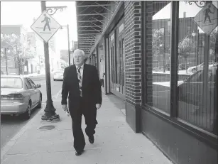  ??  ?? Ted Dolan, of Burrillvil­le, a retired Pawtucket Police Department detective captain, walks along Main Street in Woonsocket Friday morning. Dolan will be inducted into the Rhode Island Criminal Justice Hall of Fame Tuesday. He said he was reminded of...