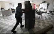  ?? CHARLES KRUPA — THE ASSOCIATED PRESS ?? Whitney Anderson wheels a recently purchased air scrubber through a classroom in advance of the school year at the E.N. White School in Holyoke, Mass., on Wednesday.