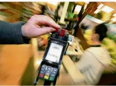  ?? SYMBOLFOTO: KARL-JOSEF HILDENBRAN­D/DPA ?? Ein Kunde bezahlt im Supermarkt mit Karte. Immer mehr Menschen ziehen Kartenzahl­ung per Girocard der Barzahlung vor.