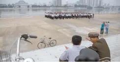  ?? AFP-Yonhap ?? Tourists, far right, take photos before the Taedong River in Pyongyang in this July 23, 2017, file photo.