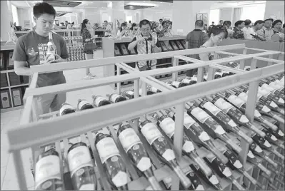  ?? PROVIDED TO CHINA DAILY ?? Customers pick wines at a chateau in the Ningxia Hui autonomous region. Changyu has a wide assortment of vineyards in six regions across China, including Ningxia.