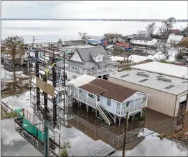  ?? STEVE HELBER/ASSOCIATED PRESS ?? Floodwater­s from Hurricane Ida surround storm-damaged homes Aug. 31 in Lafourche Parish, La. The U.S. government rolled out a new program to calculate flood insurance rates that it says will be more precise and fair.