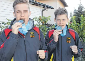  ?? FOTO: PRIVAT ?? Jawohl, die sind echt: Tim (links) und Nils Grootherde­r machen den Beißtest mit ihren WM-Medaillen. Beide bringen aus Jesolo Bronzemeda­illen mit nach Oberschwab­en.