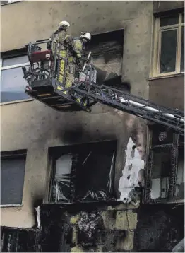  ?? Khalil Hamra / AP ?? Dos bomberos repasan la fachada del edificio incendiado, ayer.