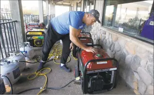  ?? Rich Pedroncell­i / Associated Press ?? Brian Boyd checks one of the generators used to provide power at the Clear Creek Crossing store near Paradise, Calif., on Thursday.