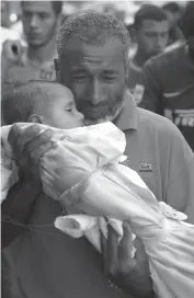  ?? — AFP
— AFP ?? A Palestinia­n man grieves as he carries his dead baby, who died of wounds sustained after a UN school in Beit Hanun was hit by an Israeli tank shell, during her funeral in Beit Lahia, northern Gaza Strip, on Friday.