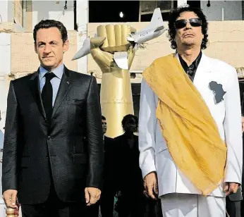  ?? Bývalý francouzsk­ý prezident Nicolas Sarkozy (vlevo) stojí vedle libyjského diktátora Muammara Kaddáfího během slavnostní ceremonie při návštěvě Libye v červenci 2007. FOTO ČTK/ AP ??