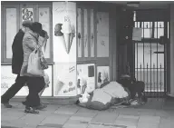  ?? STEVE PARSONS / PA VIA THE ASSOCIATED PRESS ?? A homeless person sleeps in a doorway near Windsor Castle on Thursday.