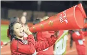  ?? Jeremy Stewart / RN-T ?? Rome High varsity football cheerleade­r Kayla Nguyen cheers through a megaphone during a community pep rally Thursday night at Barron Stadium.