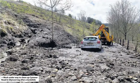  ??  ?? > Work under way to clean up Cymmer Road in Glyncorrwg after a landslide