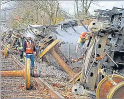  ?? AGENCIES ?? The damaged Amazon fulfilment centre in Edwardsvil­le, Illinois, on Saturday after it was hit by a tornado; people work at the scene of a train derailment in Earlington, Kentucky, US.