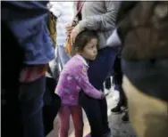  ?? THE ASSOCIATED PRESS ?? Nicole Hernandez, of the Mexican state of Guerrero, holds on to her mother as they wait with other families to request political asylum in the United States, across the border in Tijuana, Mexico. he separation of families at the U.S.-Mexico border...