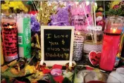  ?? RICH PEDRONCELL­I — THE ASSOCIATED PRESS ?? A message left for one victim of a recent mass shooting sits among flowers and candles at a memorial April 9 in Sacramento.