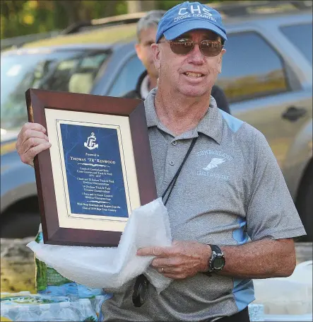  ?? Photo by Ernest A. Brown ?? Cumberland boys cross country coach Tom Kenwood received a plaque from the team’s captains prior to the final Northern Division dualmeet of Kenwood’s legendary career at the Cumberland Monastery Tuesday afternoon against Ponaganset and Central Falls.