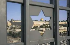  ?? Oded Balilty/Associated Press ?? Jerusalem’s Old City is seen trough a door with the shape of star of David on Tuesday. Amid widespread protests from Muslims, Israel has begun dismantlin­g metal detectors it installed a week earlier at the gates of a contested Jerusalem shrine.