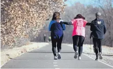  ?? MARLA BROSE/JOURNAL ?? Susan Hill, center, puts her hands on the backs of her running partners Mary Hall, right, and Celeste Herrera. The trio use running for physical and mental health, and have become good friends through the Albuquerqu­e Fit training program.
