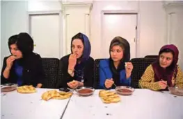  ??  ?? Afghan staff of Zan TV have their lunch at the Zan TV (Women’s TV) station in Kabul.