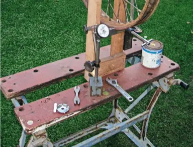  ??  ?? Below: A simple wooden jig to check the wheel was turning true. John tackled this task al fresco to take advantage of natural light