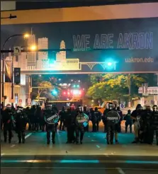  ?? Matthew Hatcher / Getty Images ?? Troopers in riot gear and police officers deployed tear gas and stun grenades Sunday to clear the area around Akron City Hall and Akron Police Station during a protest over the killing of Jayland Walker, shot by police, in Akron, Ohio.