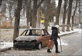  ?? Andriy Andriyenko Associated Press ?? A RESIDENT walks in a Zaporizhzh­ia town shelled by Russian forces. Ukraine’s defense minister is “optimistic” about fighter jets despite a “no” from the U.S.