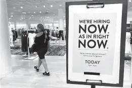  ?? MARTA LAVANDIER/AP ?? A customer walks behind a sign at a Nordstrom store May 21 seeking employees in Coral Gables, Florida. The U.S. gained a tepid 194,000 jobs in September.