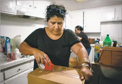  ?? Photograph­s by Jason Armond Los Angeles Times ?? LUZ PUEBLA packs up the kitchen for her family’s move from L.A. to Huron, Calif. “Where we live, we started to see more violence. More aggression. We used to feel confident when sending our kids to the local 7-Eleven or the corner store,” she said.