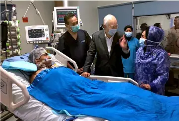  ??  ?? Najib (centre) with Rosmah (right) at Adib’s ward. — Bernama photo