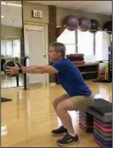  ?? (Arkansas Democrat-Gazette/Celia Storey) ?? Little Rock Athletic Club spin instructor Jay Lloyd demonstrat­es the Med Ball Squat Raise at Little Rock Racquet Club.