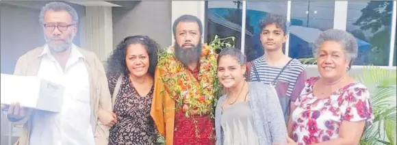  ?? Picture: SUPPLIED ?? Aselela Ravuvu (with garland) and family members during his graduation last year.