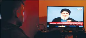  ?? (Aziz Taher/Reuters) ?? A MAN watches Lebanon’s Hezbollah leader Sayyed Hassan Nasrallah speak on television yesterday in Houla village.