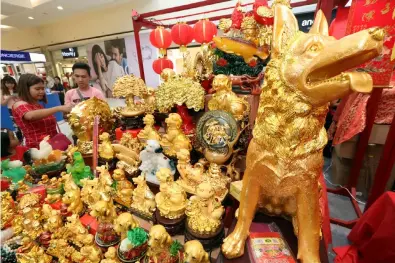  ?? Chris Navarro ?? Shoppers in a mall choose from an array of lucky charms in the Year of the Dog during yesterday’s celebratio­n of Chinese New Year. —