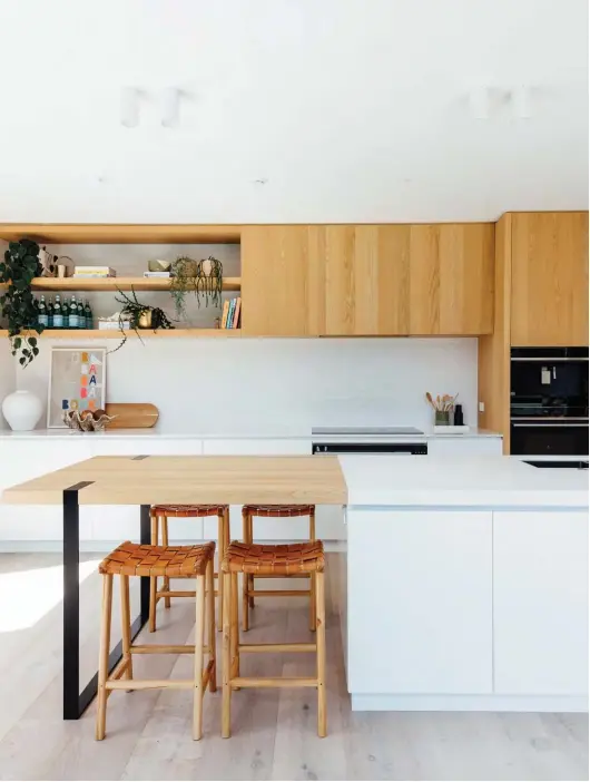  ??  ?? ABOVE Kitchen designer Robyn Labb brought the couple’s vision for the kitchen and scullery to fruition. The island benchtop is in oak and Alarti marble from Marmotec, while the back benchtop is Corian in Glacier White. The Mood Bianco splashback tiles are from Artedomus, the integrated appliances are by Fisher & Paykel and the cabinetry was constructe­d by Hewe. Hayes stools from Moi On George turn the island into a second dining table that the family gathers around daily.