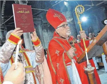  ?? FOTO: OH ?? Der Erzbischof von Mossul, Boutros Moshe, feierte die Christmett­e in der vom IS zerstörten, völlig verrußten Kathedrale von der unbefleckt­en Empfängnis im nordirakis­chen Karakosch: Moshe fordert die Christen auf, ihre Heimat wieder aufzubauen. Dafür...