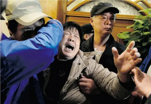  ?? GOH CHAI HIN/AFPGET TY IMAGES ?? A relative of passengers on Malaysia Airlines Flight 370 cries Monday after hearing news that the plane plunged into the Indian Ocean.