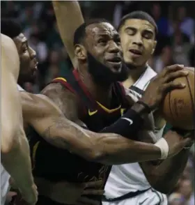  ?? CHARLES KRUPA — THE ASSOCIATED PRESS ?? LeBron James drives against the Celtics’ Marcus Smart, left, and forward Jayson Tatum during the first quarter May 23in Boston.