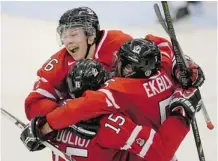  ?? Frank Gunn/The Canadian Press ?? Canada’s Curtis Lazar, top, Derrick Pouliot and Aaron Ekblad celebrate a goal Saturday during world junior hockey championsh­ip action.