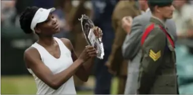  ?? TIM IRELAND — THE ASSOCIATED PRESS FILE ?? Venus Williams of the United States holds Muguruza in the Wimbledon final in July. the runners-up plate after losing to Spain’s Garbine