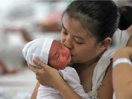  ?? Photo: Xinhua ?? A mother kisses her newborn child inside the maternity ward of the Dr. Jose Fabella Memorial Hospital in Manila, Philippine­s.