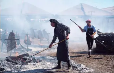  ?? BLOOMBERG/ PABLO E. PIOVANO ?? Workers prepare a traditiona­l asado during the Agroactiva fair in Armstrong, Santa Fe Province.