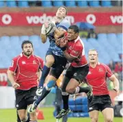  ?? Picture: RAYMOND PRESTON ?? AIRBORNE: Bulls wing Bjorn Basson, centre, gets the better of Lions fullback Chrysander Botha