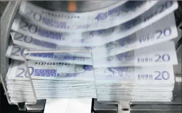  ?? FILE PHOTO: REUTERS ?? A machine counts and sorts out euro notes at the Belgian Central Bank in Brussels. Anticipati­ng a flood of more euros on to the market, the single currency tumbled over the remarks.